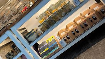 Una encimera de cocina con frascos de especias, una máquina de café y una exhibición de productos envasados.