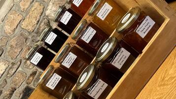 Una vitrina de madera con varios frascos de mermeladas caseras, cada uno etiquetado con el tipo de fruta utilizada.