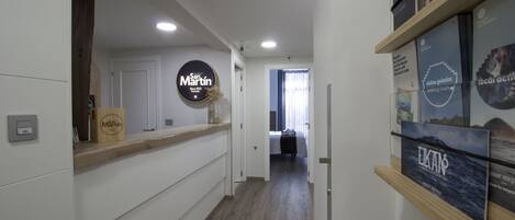 Una zona de recepción con un mostrador de madera, un cartel que dice