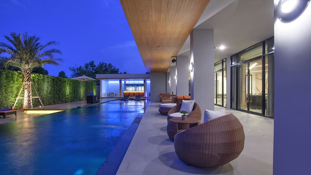 A modern outdoor pool area with seating and a view of the building's interior.