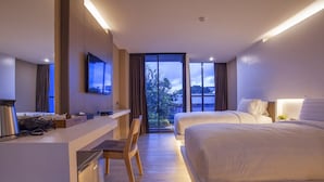 A modern hotel room with a desk, two beds, a TV, and a large window with a view.