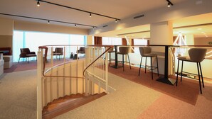 A modern interior with a staircase, seating area, and large windows. - Best Western Hotel Garda (Affi)