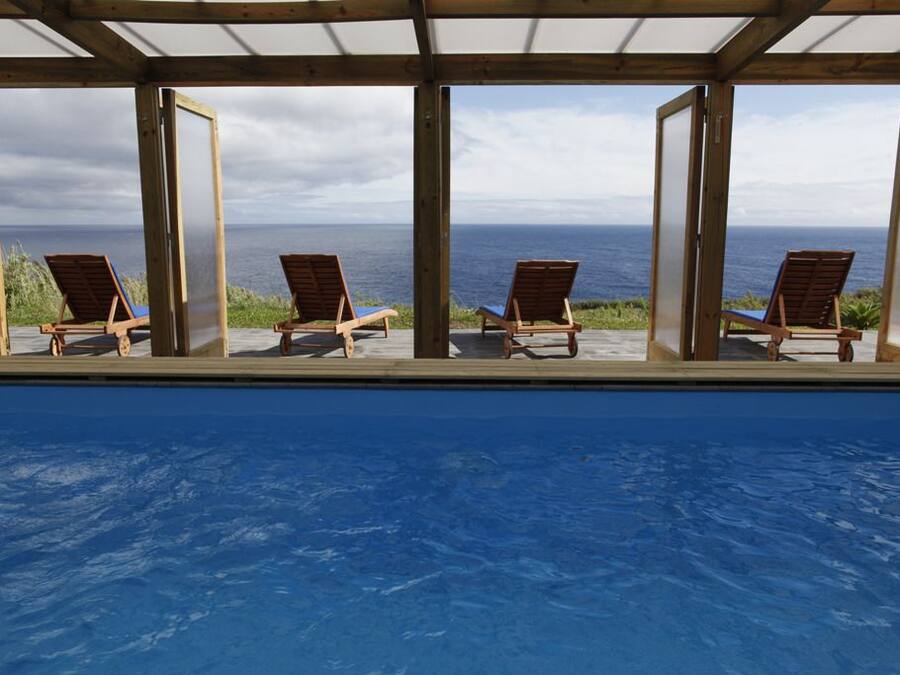 Una piscina techada, sillones reclinables de piscina