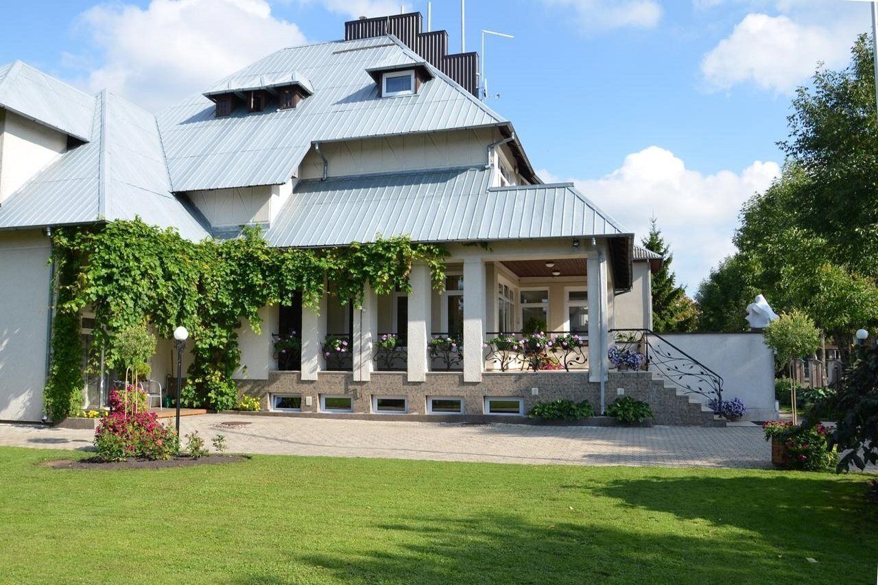 A modern house with a sloped roof, a covered porch, and a well-maintained garden.