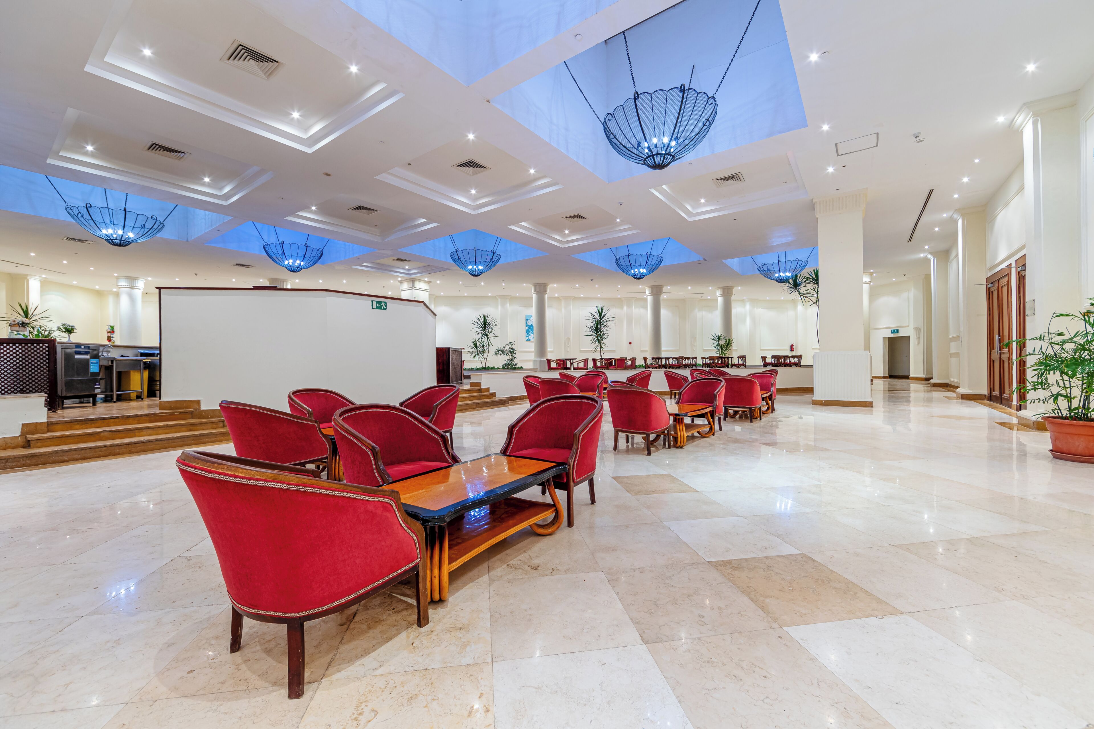 A spacious lobby with red chairs, a reception desk, and a large whiteboard.