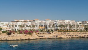 A large resort hotel with multiple balconies, palm trees, and a beach area. - Siva Sharm Resort & Spa  (Sharm El Sheikh)