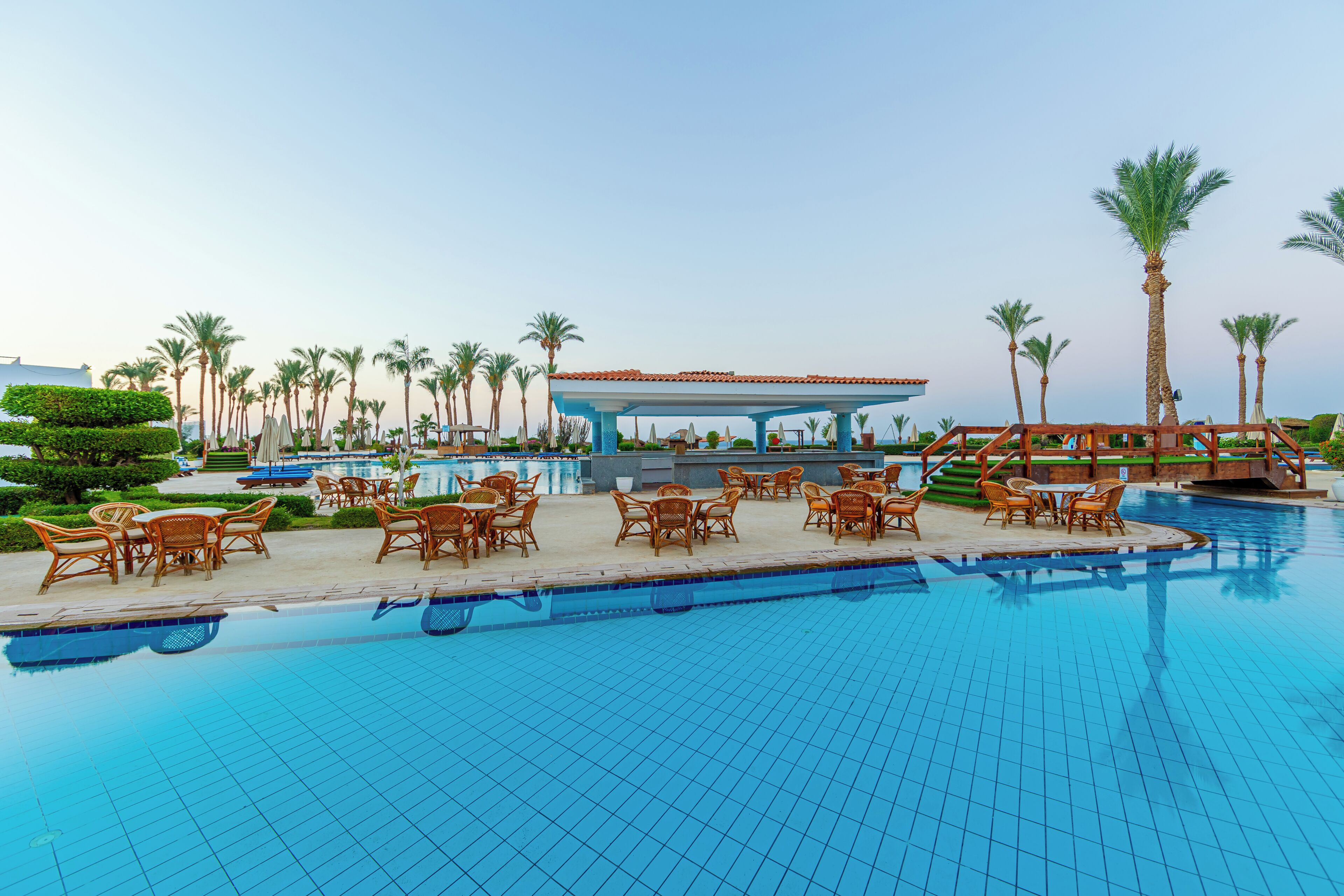 A swimming pool with lounge chairs and a pavilion.