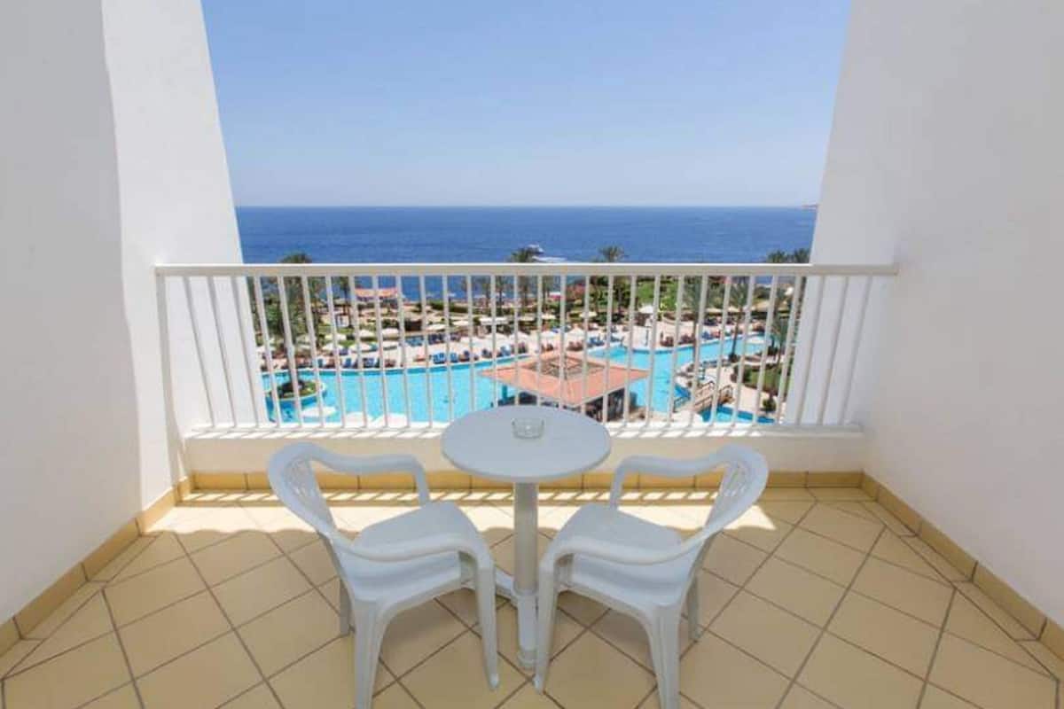 A balcony with a view of a pool and resort area.
