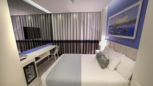 A modern hotel room with a bed, a desk, a television, and a painting on the wall. - Ravvda Hotel Bakırköy (Istanbul)