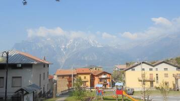 A residential area with houses, a playground, and a mountain backdrop.