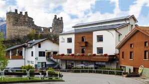 A hotel with a stone tower in the background, a bar, and a restaurant. - B&B Castello (Cimbergo)