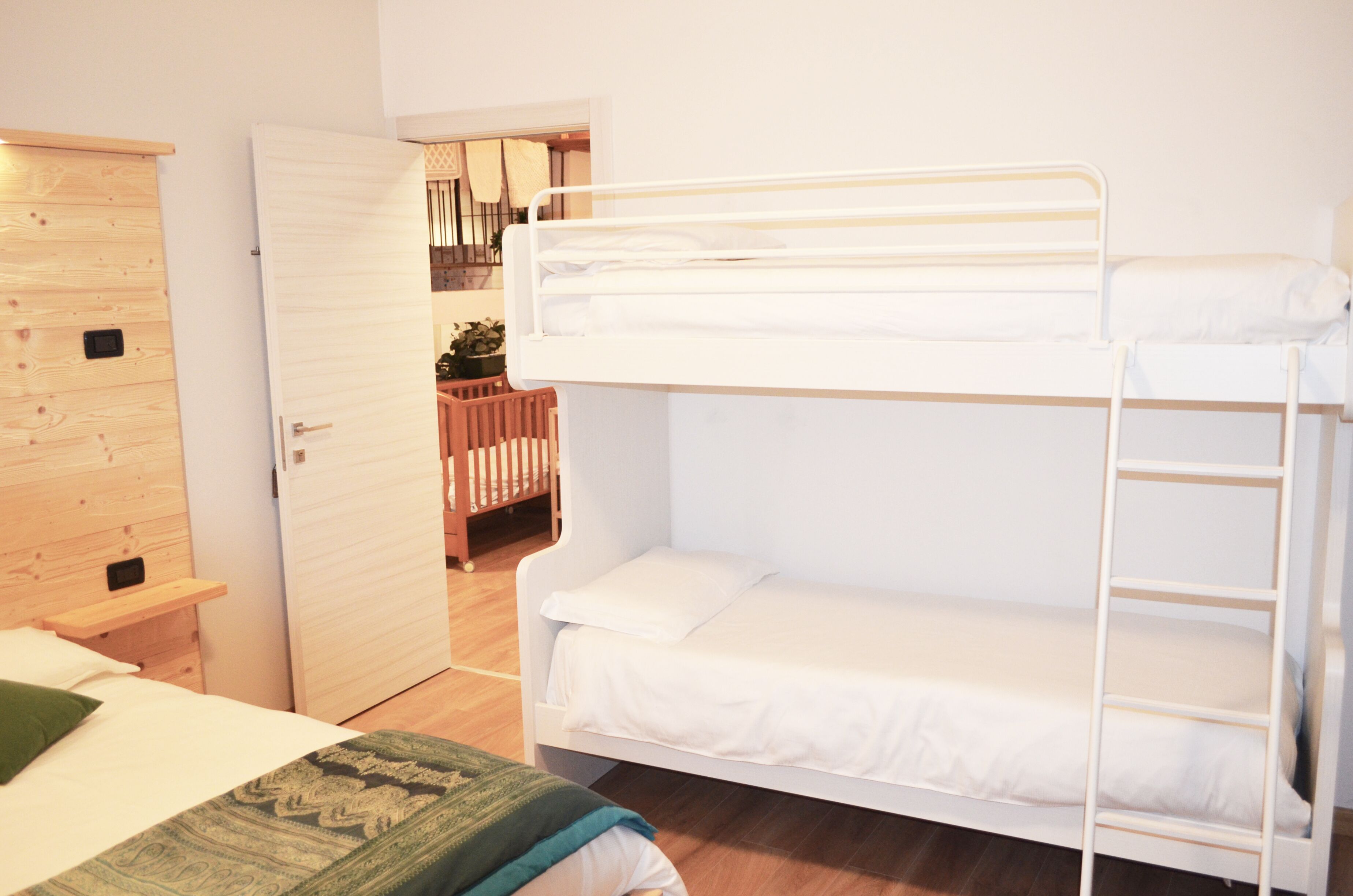 Une chambre avec un lit superposé, une armoire en bois et un petit bureau.