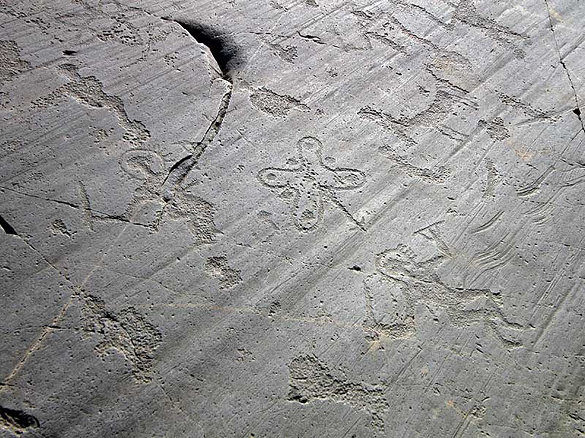 A close-up of a stone surface with carved patterns, possibly ancient or decorative.