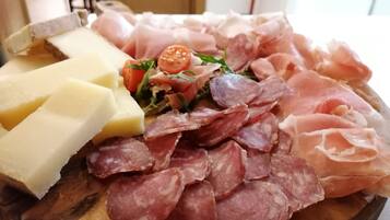 A charcuterie board with various meats, cheeses, and vegetables.