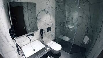 Ein modernes Badezimmer mit Marmorwaschtisch, Toilette und einer Duschkabine.