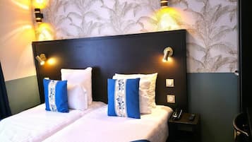 Una habitación de hotel con una cama grande, dos mesitas de noche, un teléfono y un aparador.