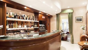 Un espace bar avec des étagères remplies de bouteilles d’alcool, un comptoir et un coin repas avec des chaises et une table.