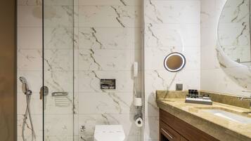 Een moderne badkamer met een douchecabine van glas, een toilet en een wastafel met spiegel.