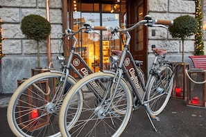 Dos bicicletas estacionadas frente a un edificio con paredes de piedra y una puerta de madera.
