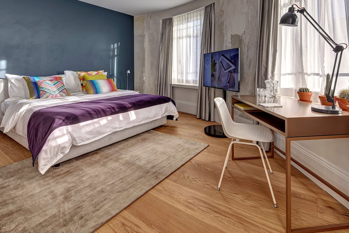 A modern bedroom with a bed, desk, and chair.