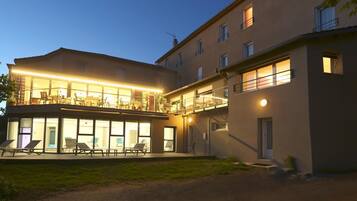 Vista frontal de la propiedad por la tarde o noche