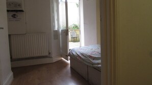A bedroom with a bed, a radiator, and a door leading to a balcony. - No 8 Apartments (Bristol)