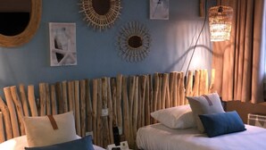 A room with two beds, a wooden headboard, wall art, and a hanging light fixture. - Hôtel Burnichon (Vindry-sur-Turdine)