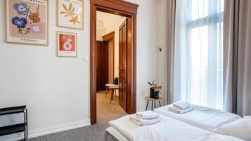Une chambre d’hôtel avec un lit, un bureau et une vue sur un couloir.