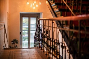 A staircase with a metal railing leading to a door with glass panels. - Aparthotel Maargick (Kraków)