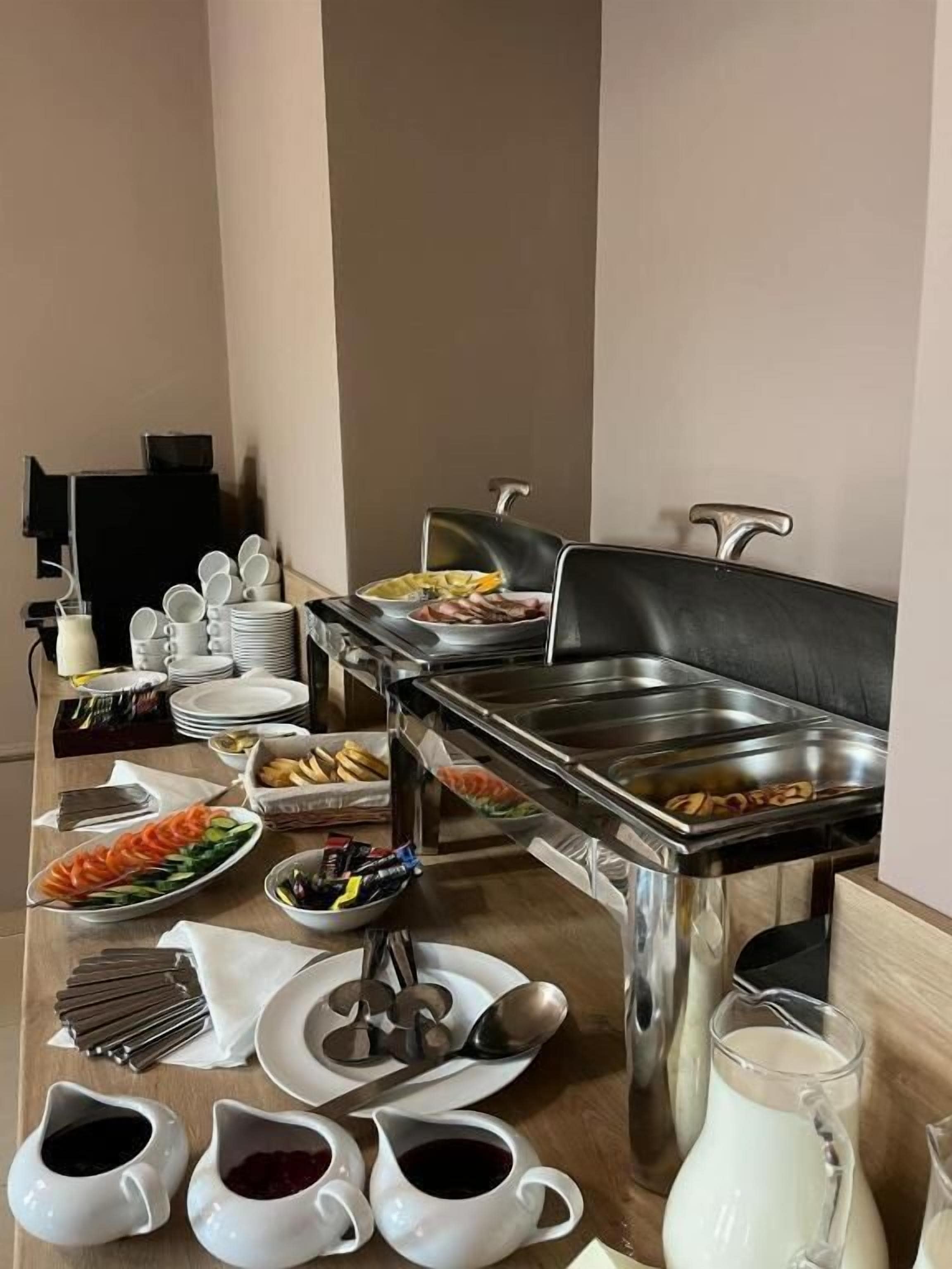 A buffet setup with various food items and serving utensils.