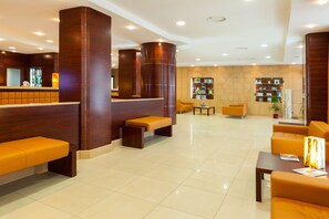 A modern lobby with wooden reception desk, seating areas, and a well-lit space. - BV President Hotel (Rende)