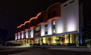 A multi-story hotel with a modern design, featuring a prominent entrance with a covered walkway and outdoor seating area. - BV President Hotel (Rende)