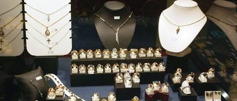 A jewelry store with multiple display cases of necklaces and bracelets.