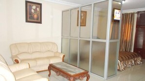 Una sala de estar con un sofá color crema, una mesa de centro de madera y una pared de cristal corredera.