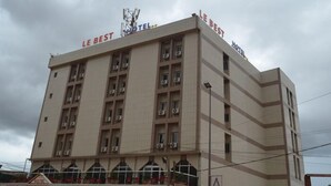 Un hotel con varios pisos, unidades de aire acondicionado y un cartel que indica que es 'Le Best Hotel'.