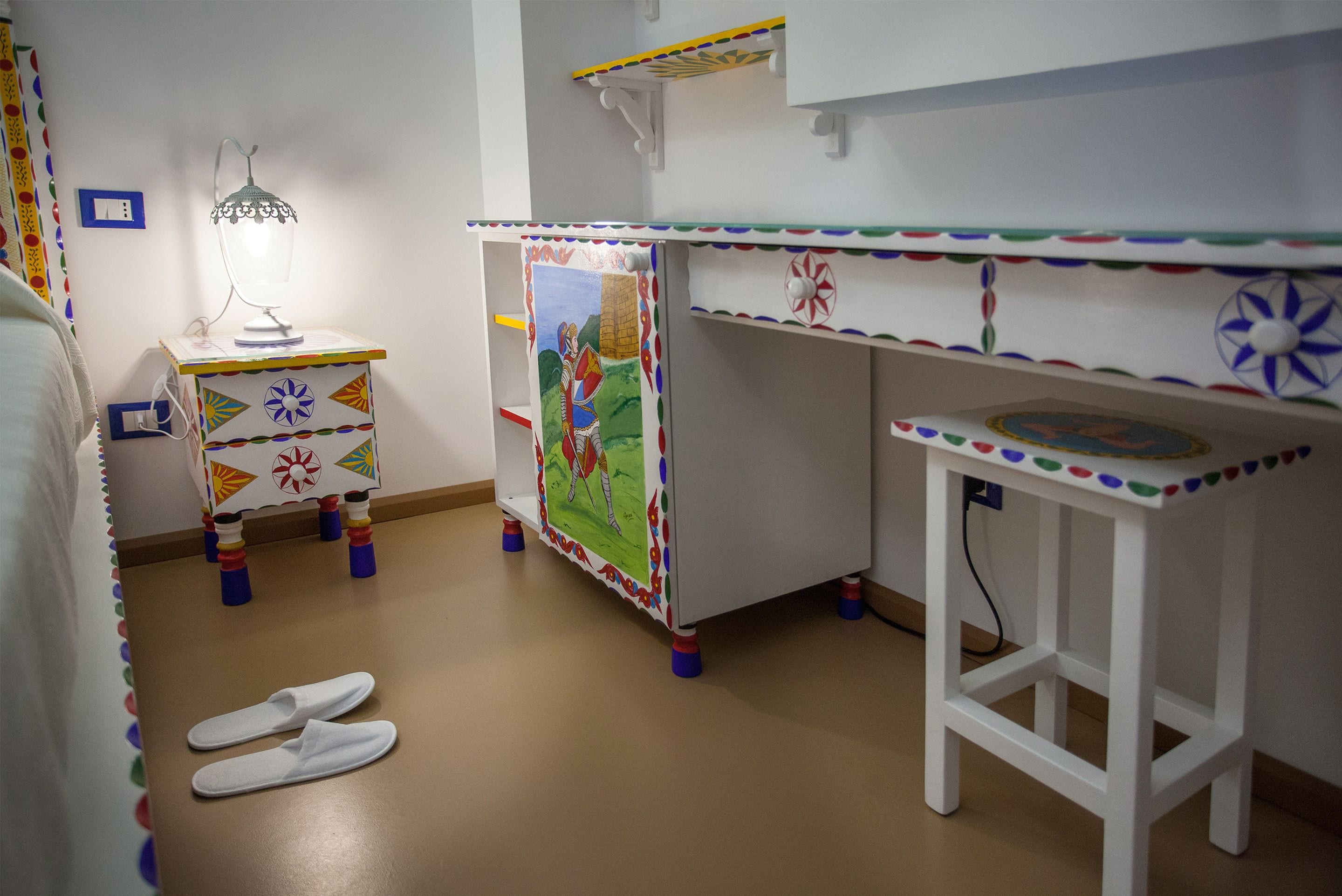 Una sala de juegos infantil con una mesita, una silla y un par de zapatillas en el suelo.