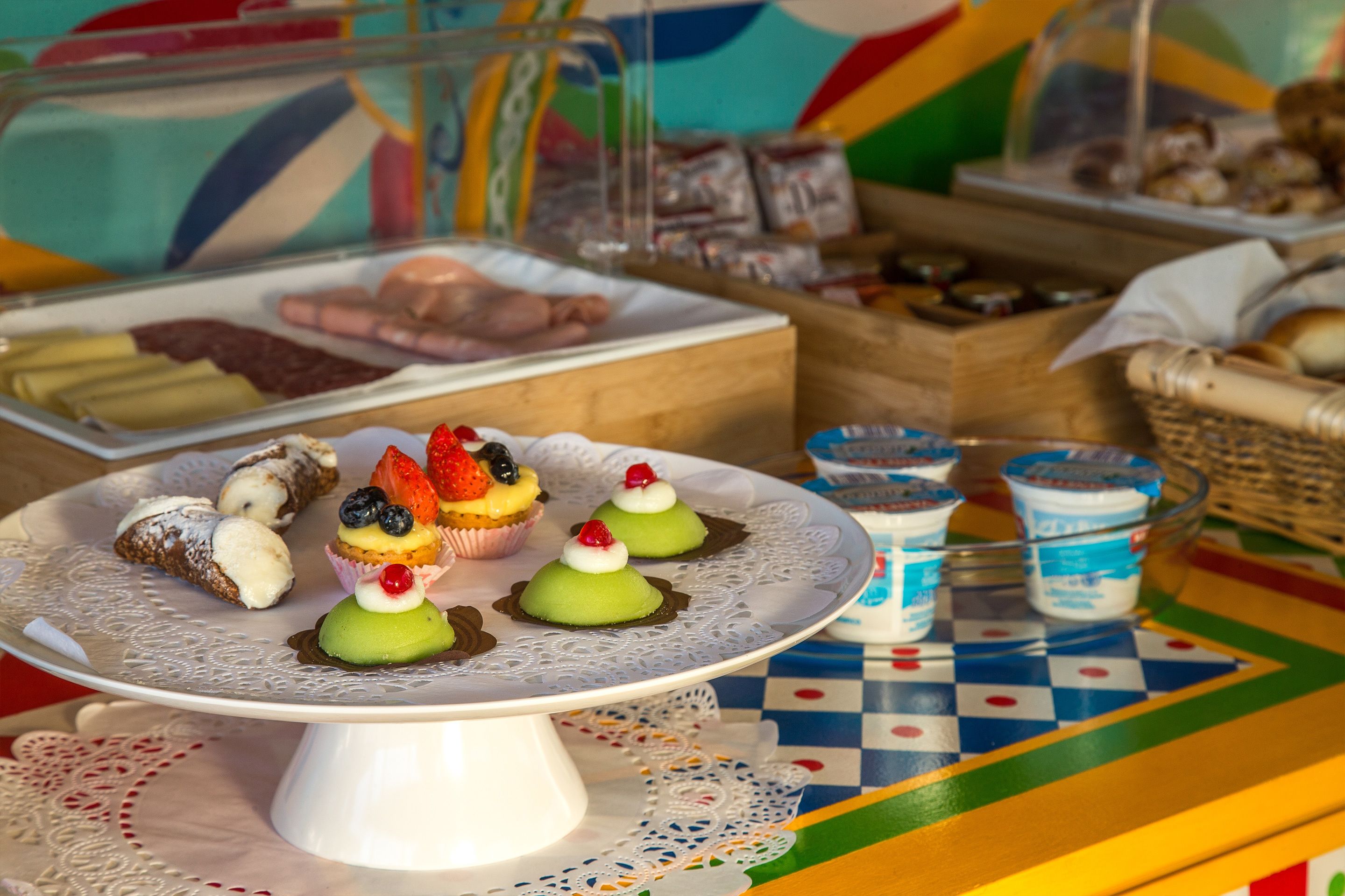 A dessert display with various pastries and a checkered tablecloth.