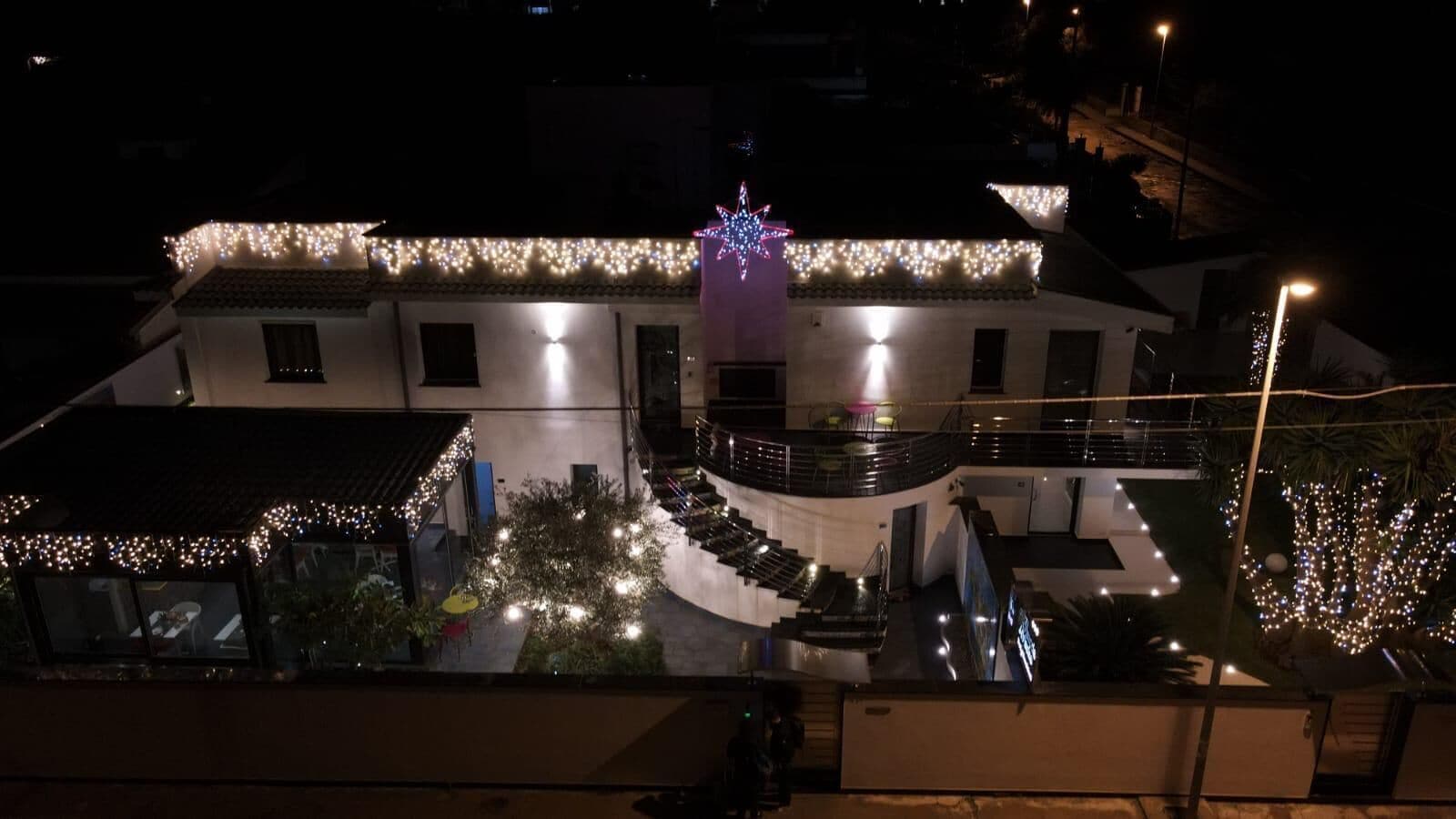 A building with multiple floors, outdoor seating areas, and a central stage with a star-shaped light decoration.