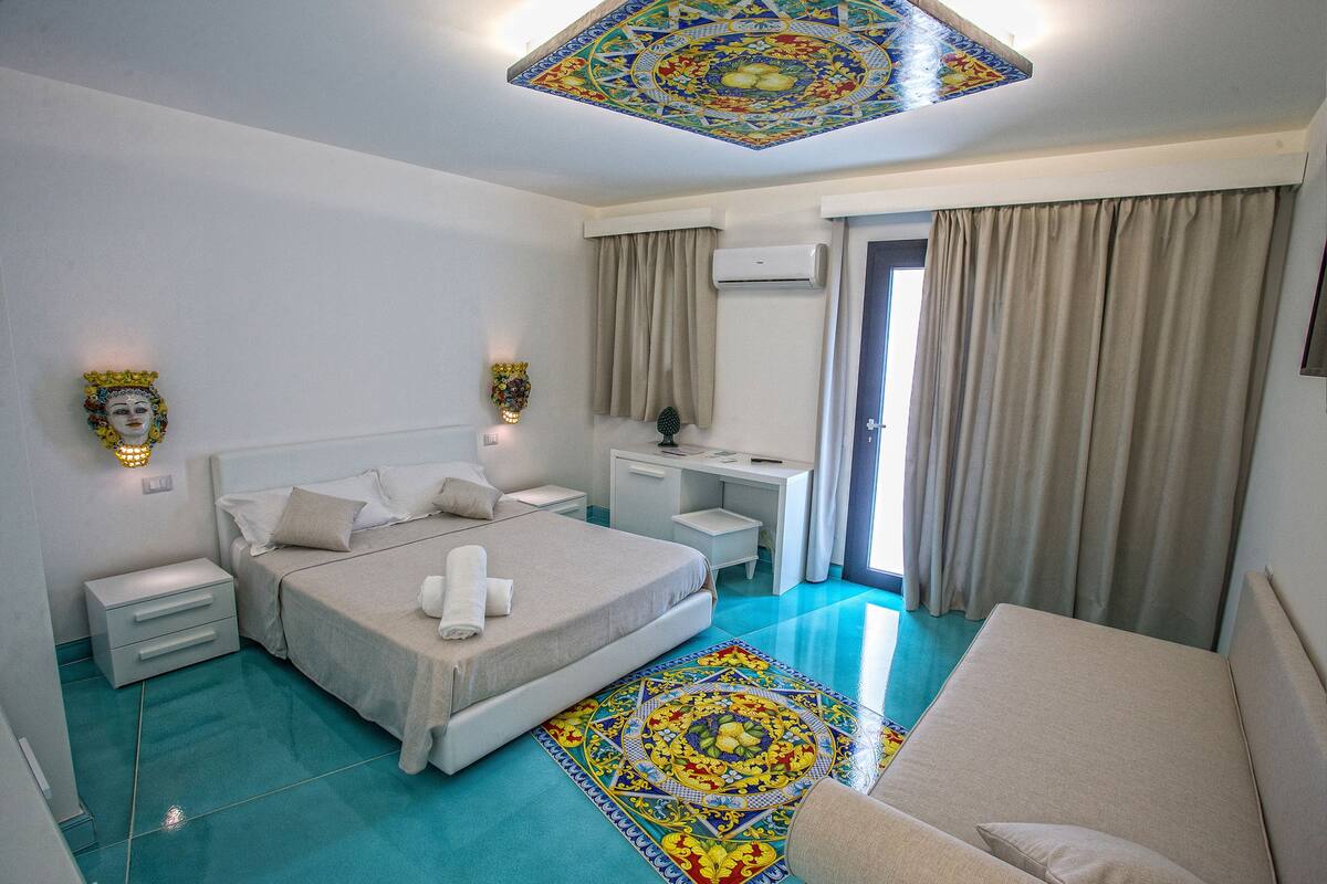 Een slaapkamer met een bed, nachtkastjes, een bureau en een stoel.
