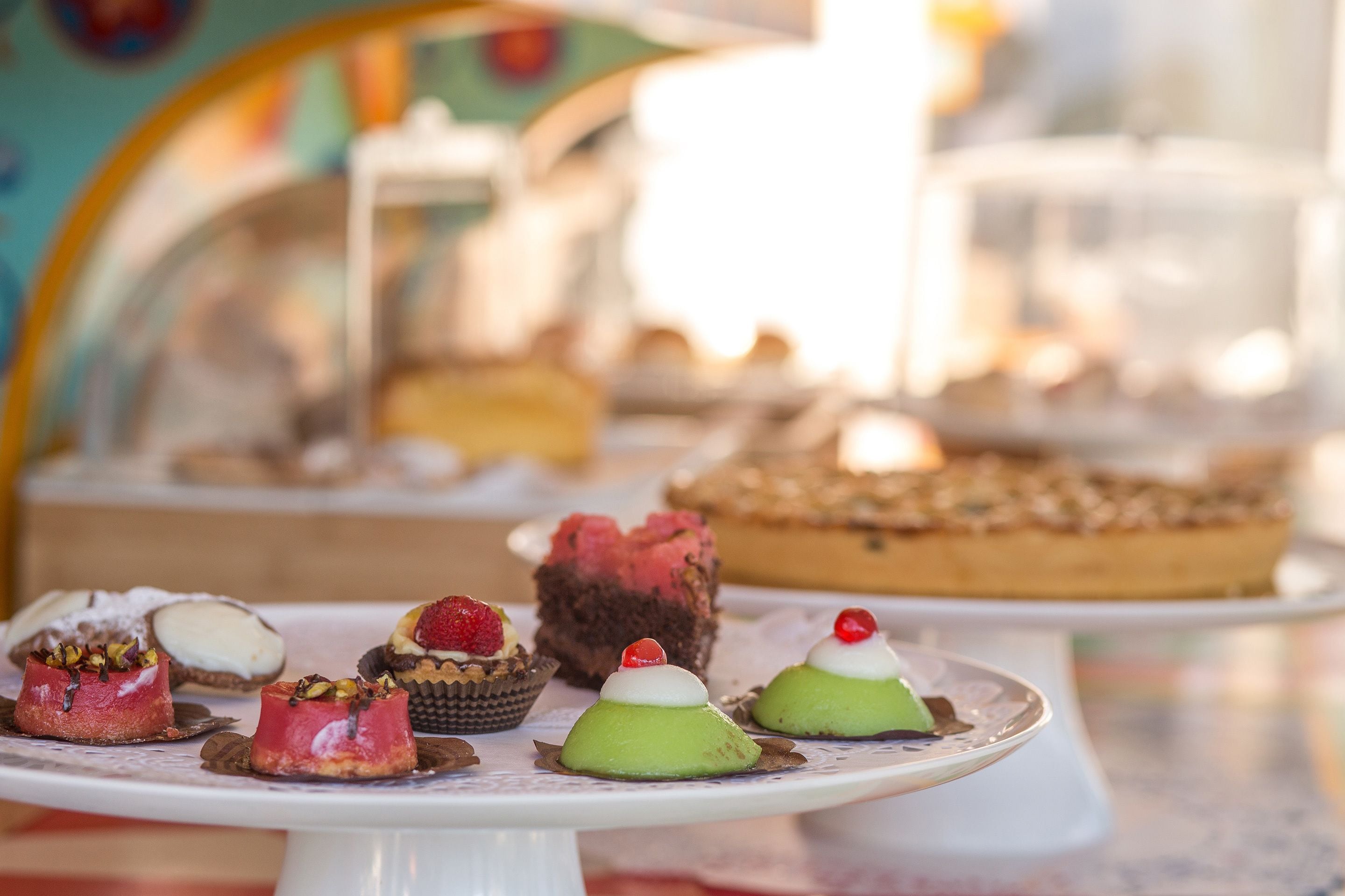 A dessert display with various cakes and pastries on a white stand.