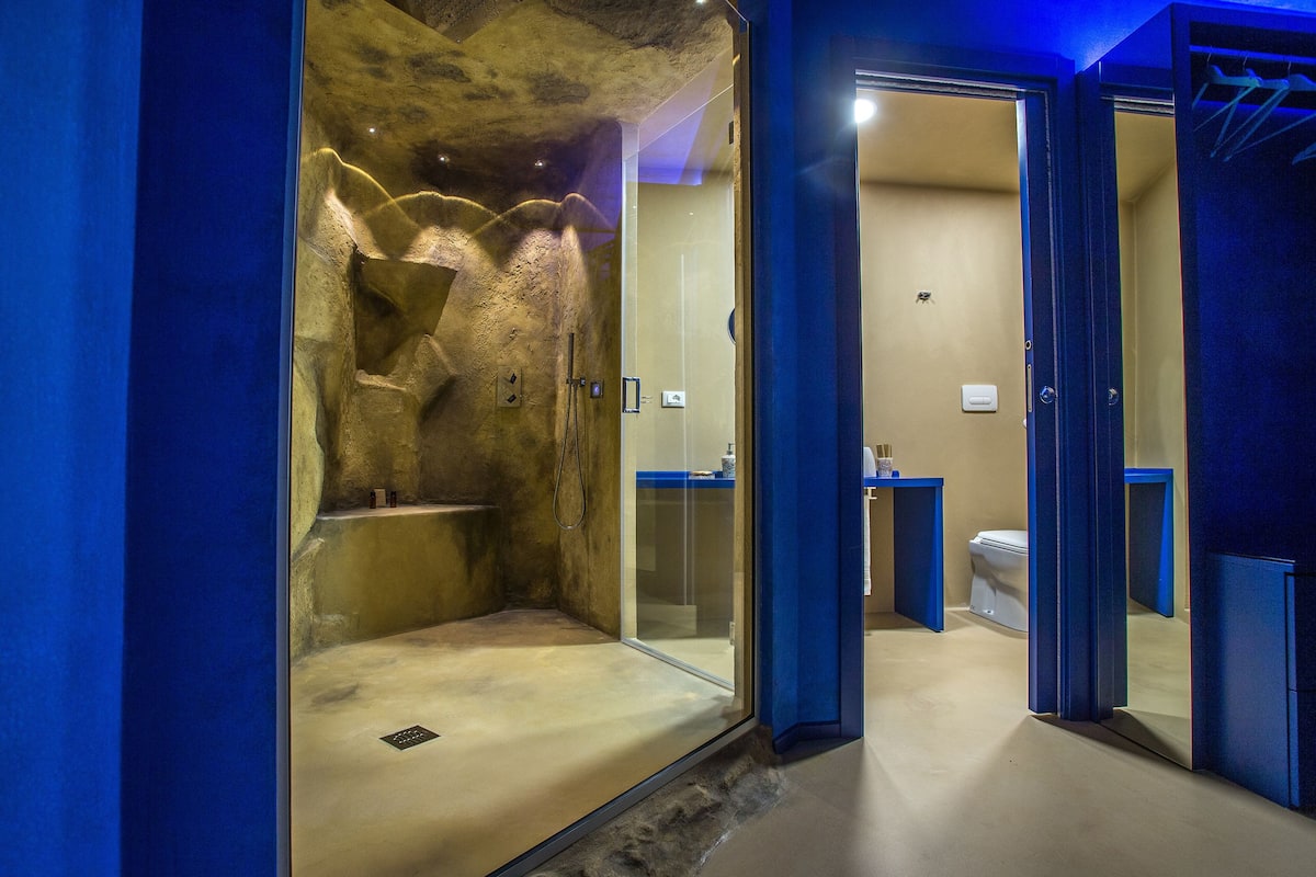 Een moderne badkamer met een douchecabine, toilet en wastafel.