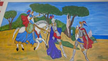 A painting of three knights in armor, one on a horse, and two on foot, with a tree and a body of water in the background.