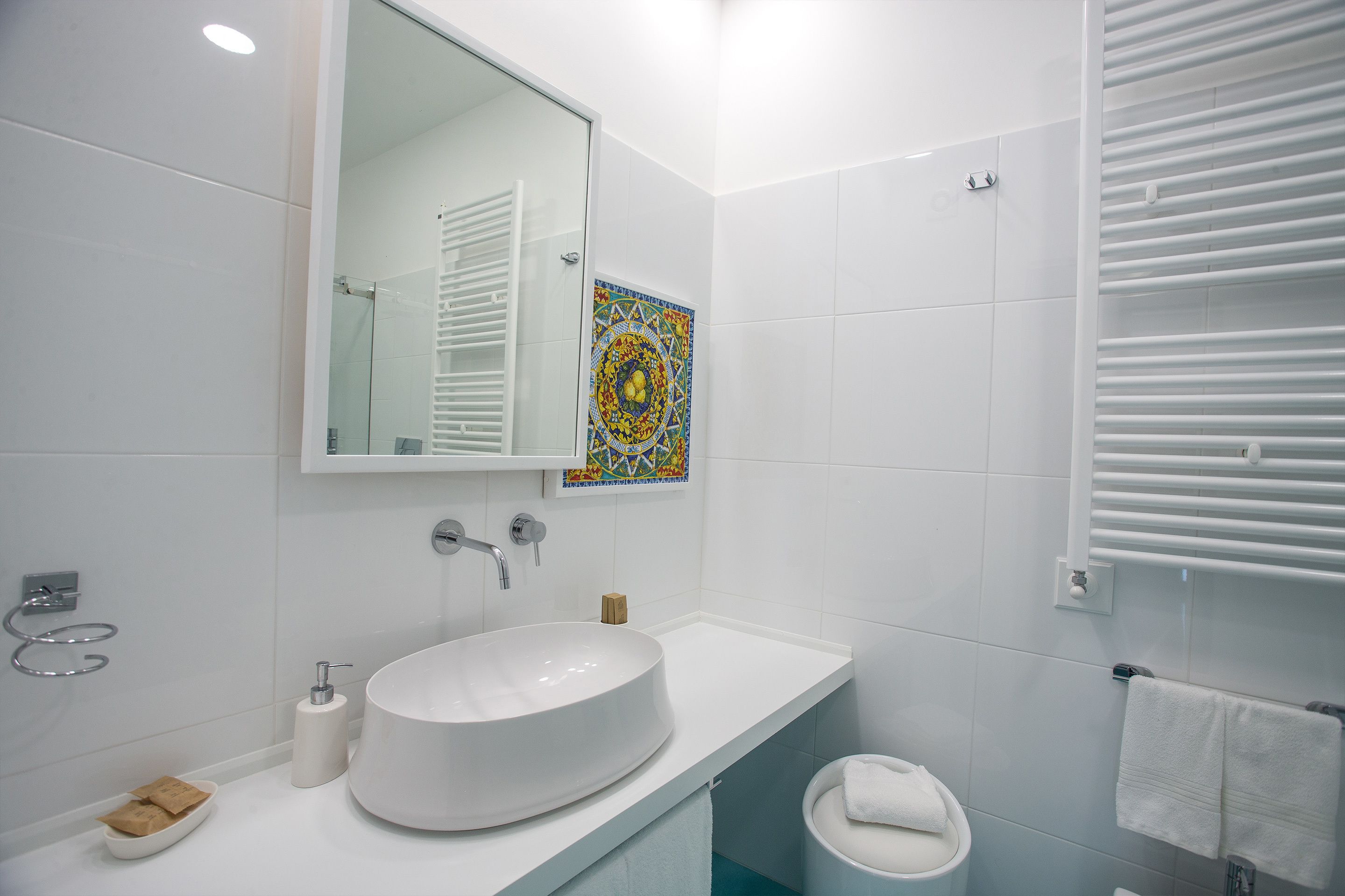 Une salle de bain moderne avec un grand lavabo blanc, un miroir et un espace douche.