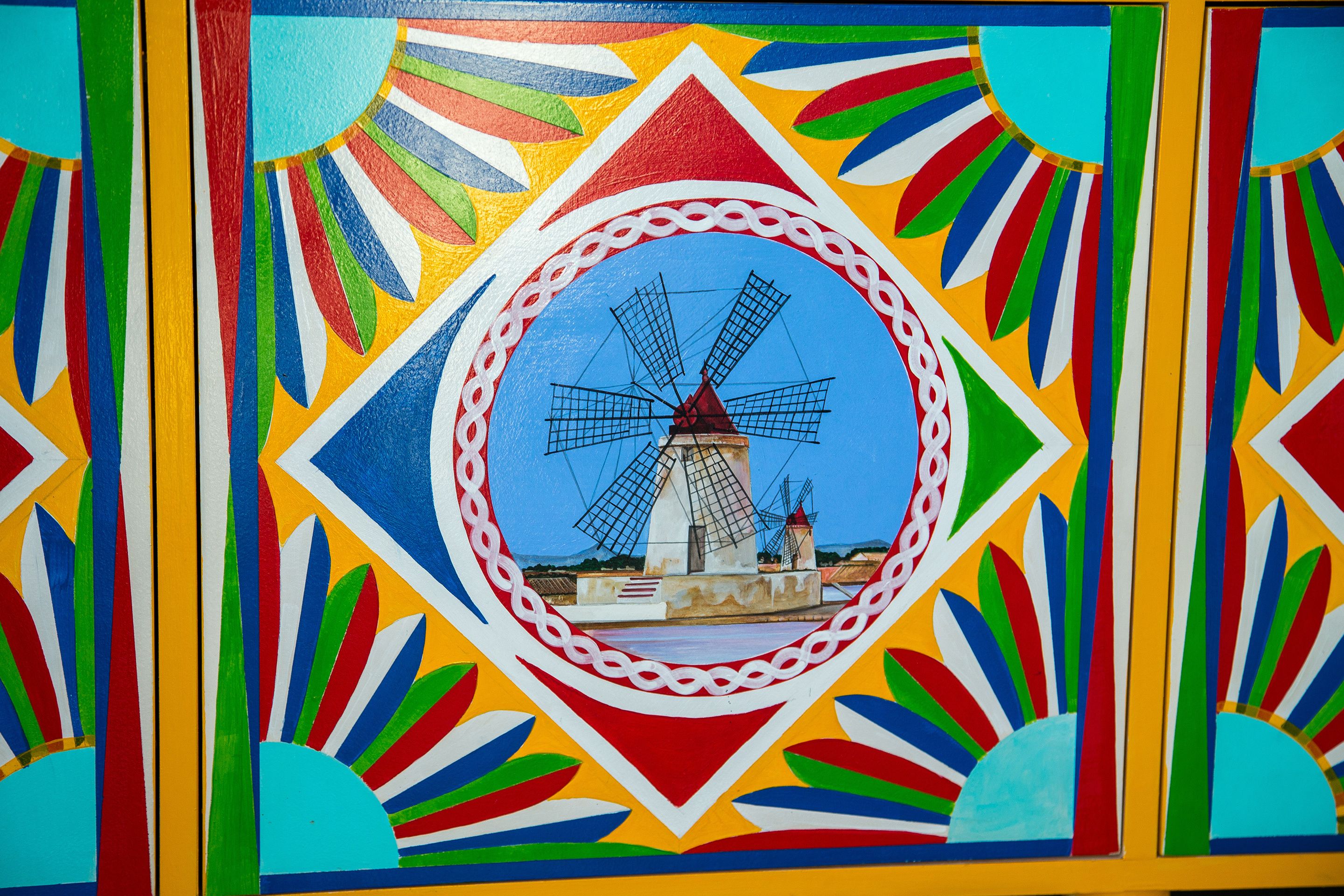 Un mural colorido con un molino en el centro.