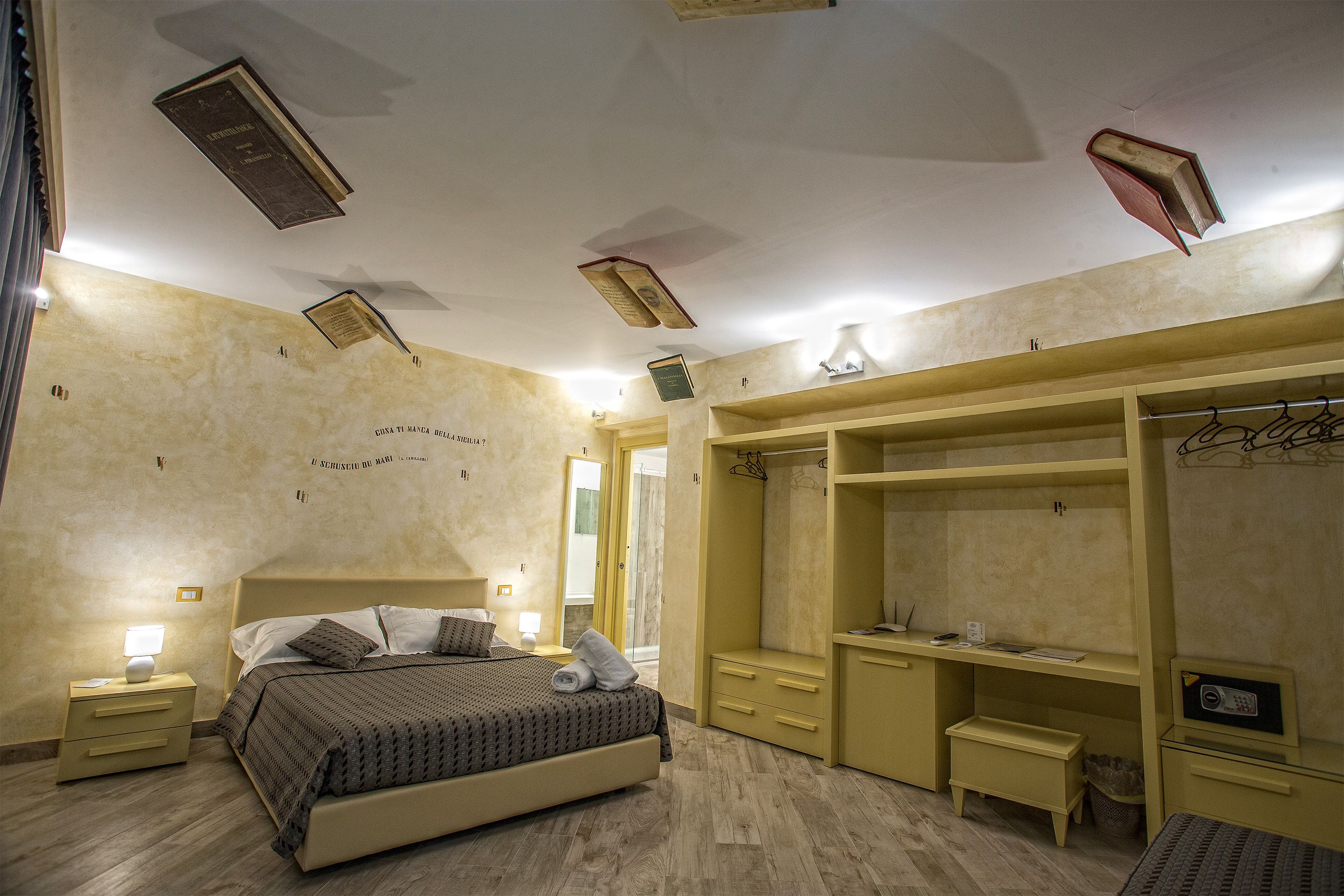 A bedroom with a bed, bedside tables, a wardrobe, and a desk.