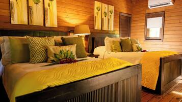 A wooden-paneled room with two beds, each with patterned bedding and pillows.