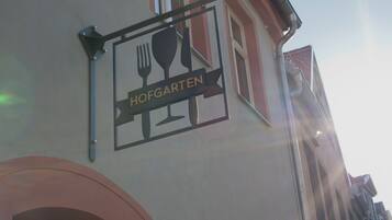 Un edificio con un letrero que dice "HOFGARTEN" y una estructura metálica encima.