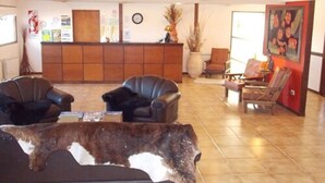 A lobby with leather chairs, a reception desk, and a large animal head sculpture.