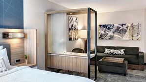 A hotel room with a bed, a desk with a chair, a sofa, and a large abstract painting on the wall. - SpringHill Suites Oklahoma City Midwest City/Del City (Del City)