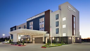 A modern hotel with a flat roof, a covered entrance, and a flagpole. - SpringHill Suites Oklahoma City Midwest City/Del City (Del City)